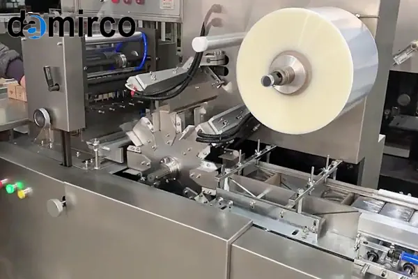 یک دستگاه سلفون کش جعبه در حال بسته‌بندی یک جعبه کوچک سفید