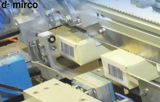 نمایی از یک خط تولید دارویی مجهز به سیستم تایید اصالت دارو که در حال چاپ کد رهگیری روی بسته‌بندی است.