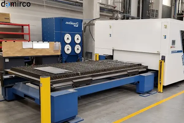 یک دستگاه برش لیزر دست دوم در حال برش ورق فلزی در یک کارگاه صنعتی