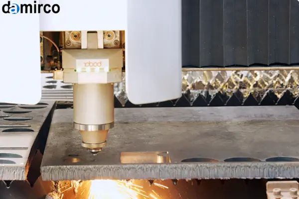 نمای نزدیک از هد دستگاه برش لیزر در حال برش ورق فلزی با جرقه های درخشان