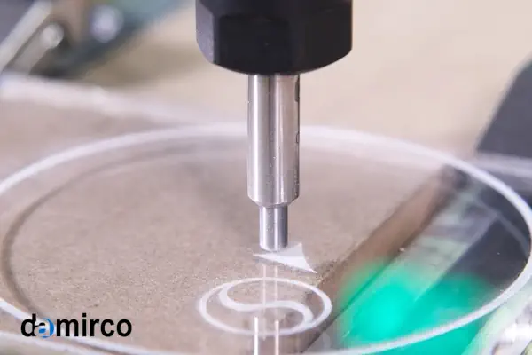 یک دستگاه حکاکی لیزری در حال حکاکی طرحی دقیق روی یک پلاک فلزی