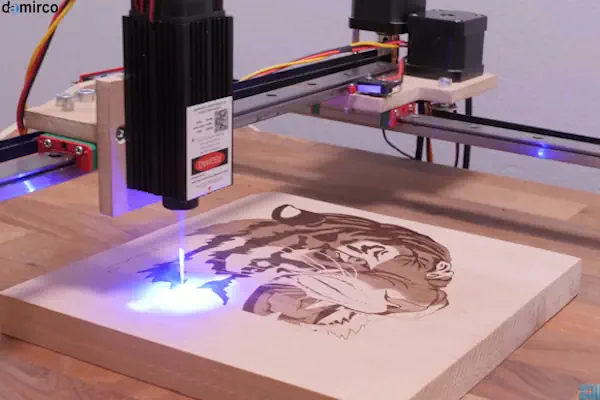 یک طراح صنعتی در حال کار با نرم افزار طراحی برای دستگاه حکاکی لیزری روی کامپیوتر