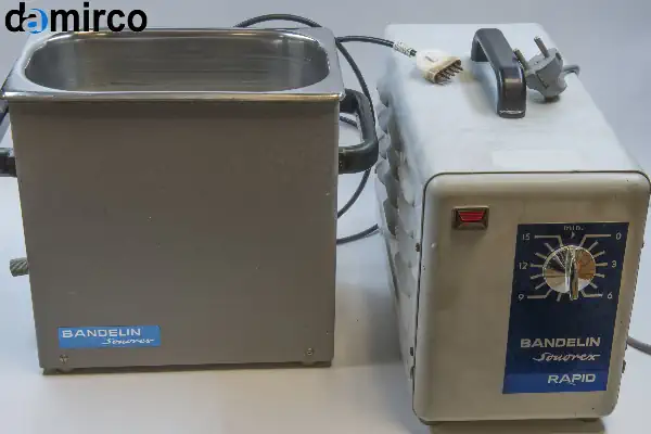 نمای نزدیک از یک قطعه صنعتی زنگ زده در حال تمیز شدن توسط دستگاه زنگ زدای التراسونیک