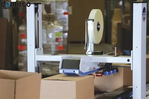 اپراتور در حال تنظیم دستگاه چسب زن کارتن در یک خط بسته‌بندی صنعتی