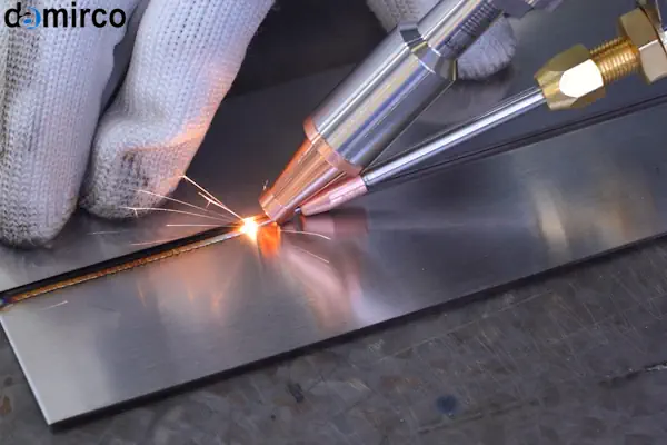 اپراتور در حال انجام جوشکاری لیزری با استفاده از عینک ایمنی مخصوص و لباس محافظ کامل در یک محیط صنعتی