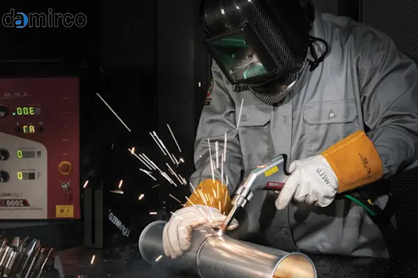 یک اپراتور در حال استفاده از دستگاه جوش لیزر دستی برای جوشکاری یک قطعه فلزی با دقت بالا.