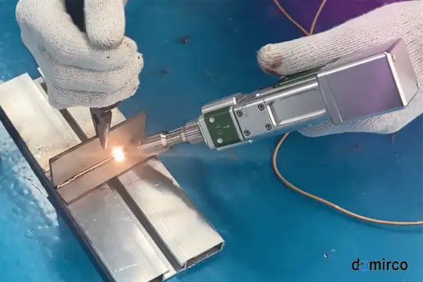 یک دستگاه جوش لیزر دستی در حال کار بر روی قطعه فلزی با دقت بالا
