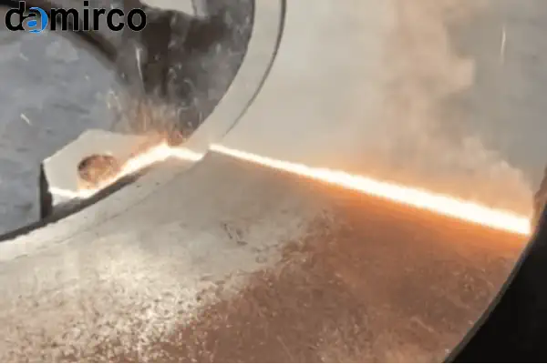 یک اپراتور در حال استفاده از دستگاه زنگ زدای لیزری دستی برای پاک کردن زنگ از روی یک قطعه فلزی صنعتی