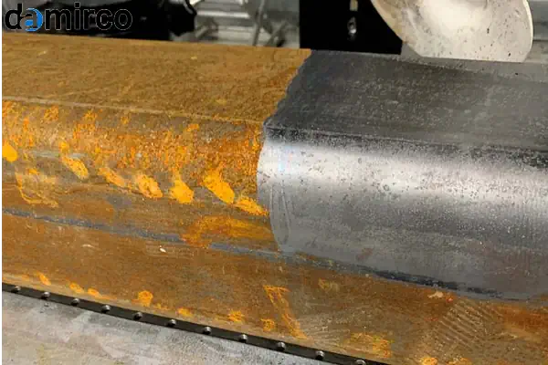 تصویر مقایسه‌ای دستگاه زنگ زدایی لیزری در حال کار کنار یک دستگاه سندبلاست