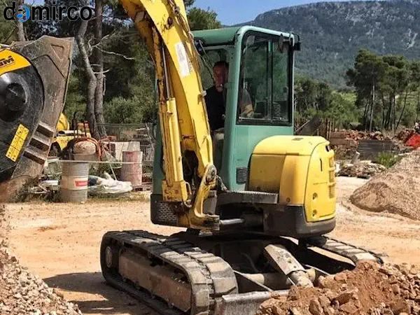 تصویر یک دستگاه سنگ شکن کوبیت (ضربه ای) آبی رنگ در یک کارخانه تولید مصالح ساختمانی