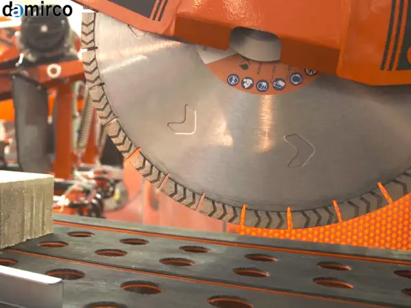 تکنسین متخصص در حال تعمیر دستگاه برش سنگ در یک کارگاه صنعتی