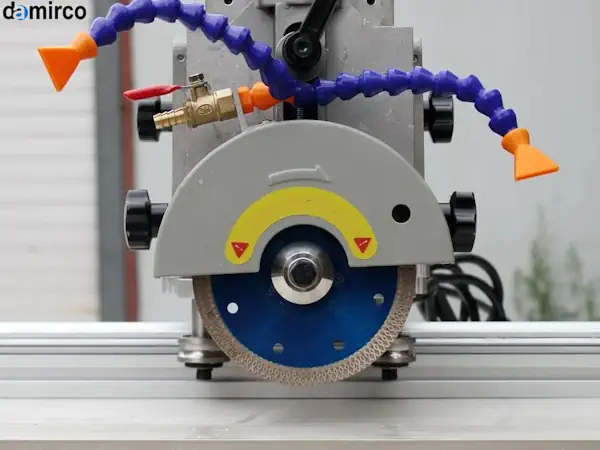 یک دستگاه برش سنگ قابل حمل در حال برش یک قطعه سنگ گرانیت در یک کارگاه ساختمانی