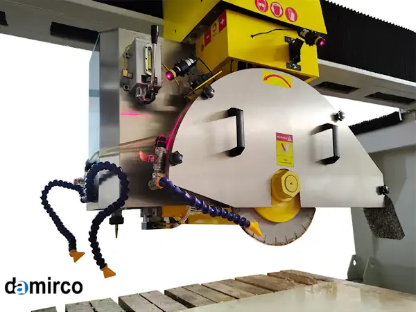 یک دستگاه برش سنگ فرز صنعتی در حال برش یک اسلب بزرگ سنگ گرانیت با دقت بالا و پاشش آب