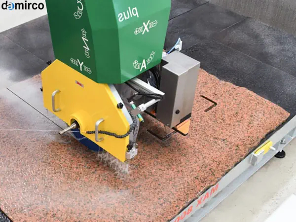 یک دستگاه برش سنگ اسلب پیشرفته در حال برش یک اسلب گرانیت بزرگ در یک کارخانه سنگ‌بری مدرن