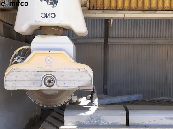 اپراتور در حال کار با دستگاه برش سنگ صنعتی و تنظیم تیغه آن