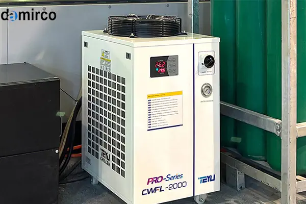 تصویر یک دستگاه چیلر لیزر صنعتی در کنار دستگاه برش لیزری در یک کارگاه