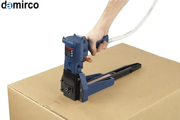 تصویر مقایسه‌ای از یک دستگاه منگنه کوب کارتن دستی در کنار یک مدل بادی در یک کارگاه صنعتی