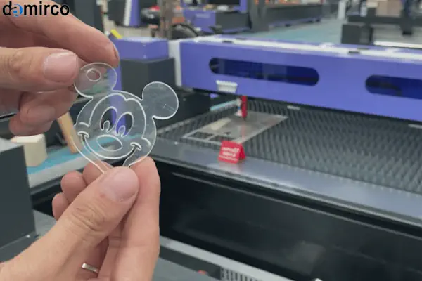 دستگاه لیزر CO2 در حال برش یک طرح پیچیده روی ورق پلکسی گلاس شفاف