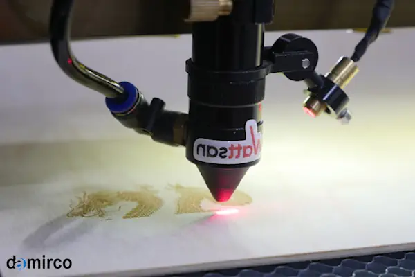 تصویر یک دستگاه حکاکی لیزری صنعتی در حال کار بر روی یک قطعه چوبی با دقت بالا