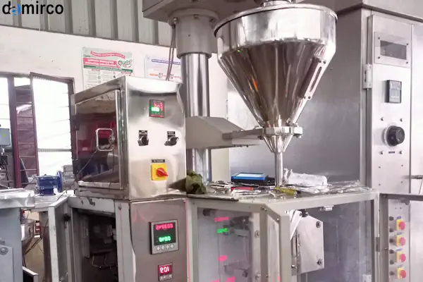 یک دستگاه پرکن پودر قهوه صنعتی در حال بسته‌بندی پودر قهوه در پاکت‌های مخصوص سوپاپ‌دار