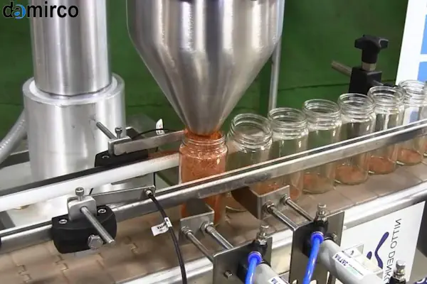 دستگاه پرکن ادویه در حال پر کردن ظروف شیشه‌ای با ادویه جات رنگارنگ